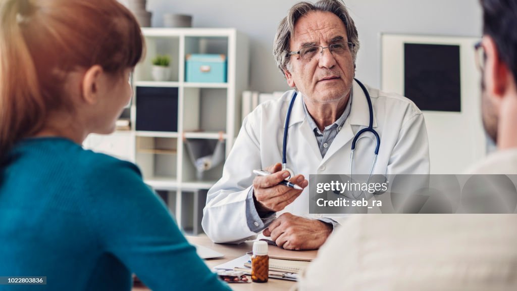 Doctor talking a young couple of patients