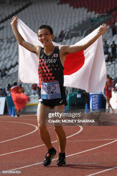 Japan's Hiroto Inoue holds his national flag after winning the men's marathon athletics event during the 2018 Asian Games in Jakarta on August 25,...