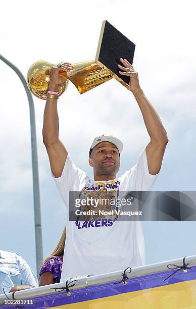 Los Angeles Lakers point guard Derek Fisher hoists the championship trophy while riding in the victory parade for the the NBA basketball champion...