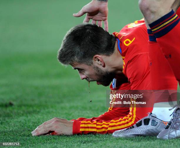 Gerard Pique of Spain is injured with blood coming from his mouth during the 2010 FIFA World Cup South Africa Group H match between Spain and...
