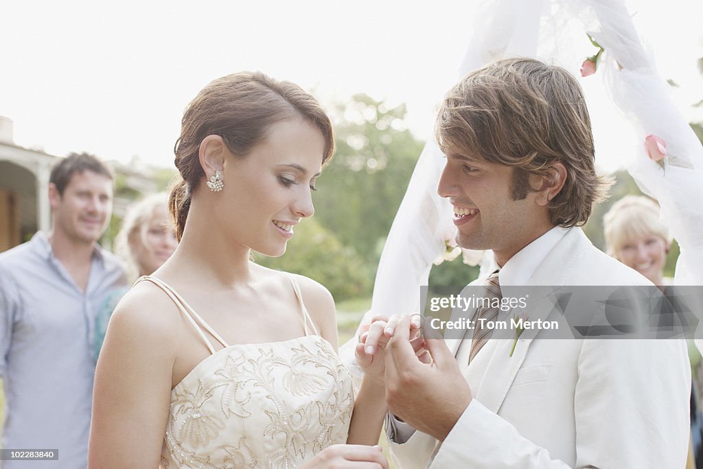 Novio putting anillo de dedo sobre las novias
