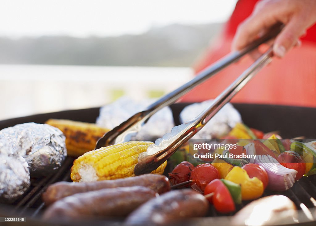 Close up of man grilling food on barbecue