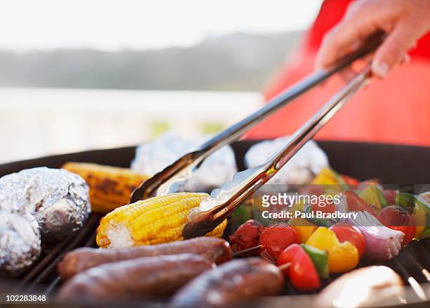 close up of man grilling food on barbecue - barbeque stockfoto's en -beelden