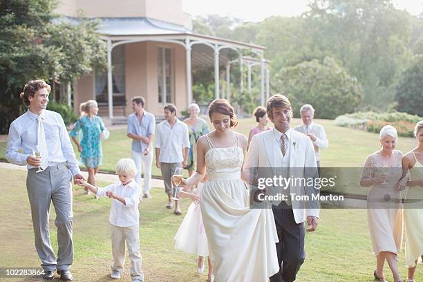 bride, groom and guests walking across lawn - australia marriage stockfoto's en -beelden