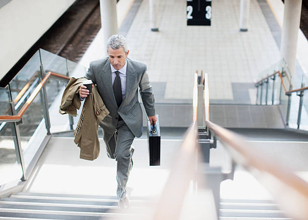 Businessman walking up stairs in train station