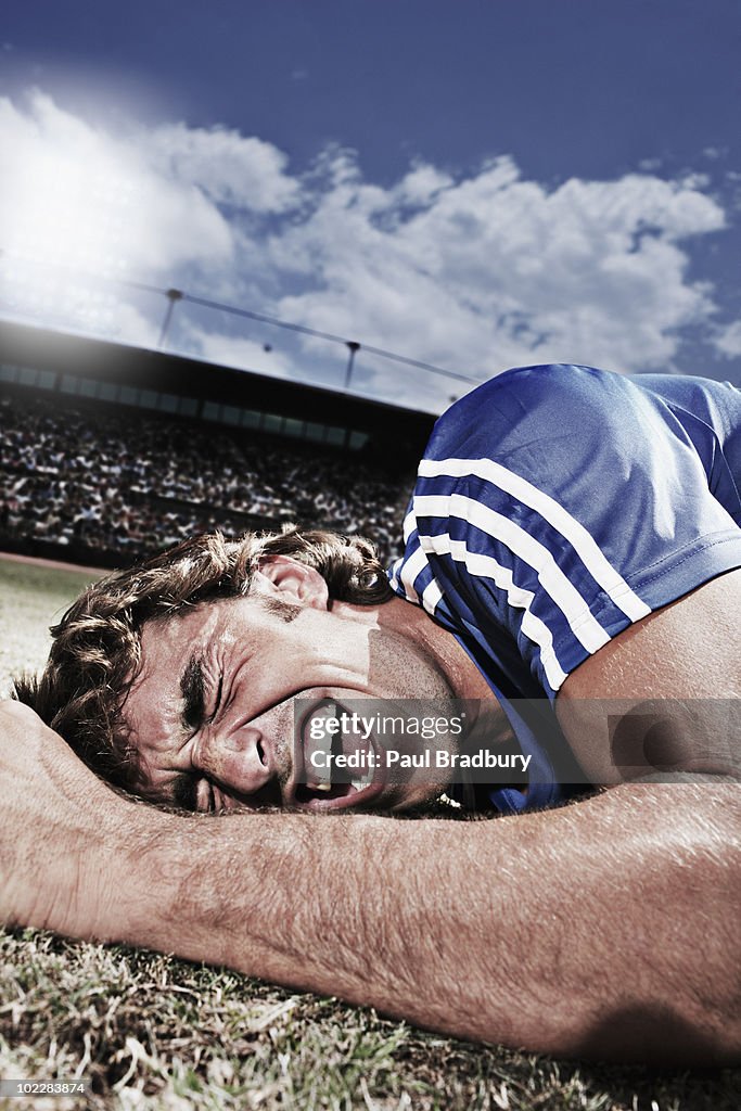 Frustrated soccer player laying on ground