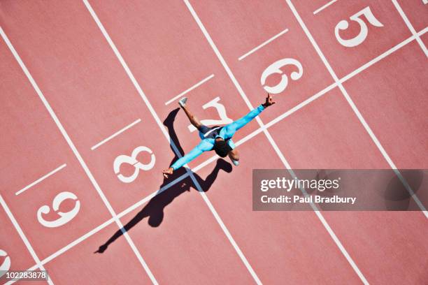runner crossing finishing line on track - mållinje sportutrustning bildbanksfoton och bilder