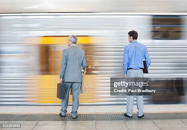 businessmen watching speeding train - railway station stock pictures, royalty-free photos & images