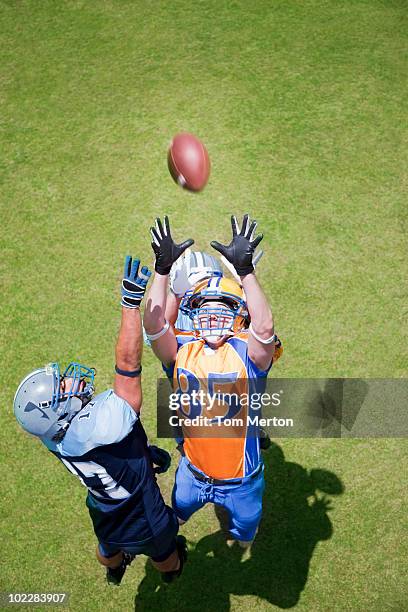 football player catching football - tackle american football positie stockfoto's en -beelden