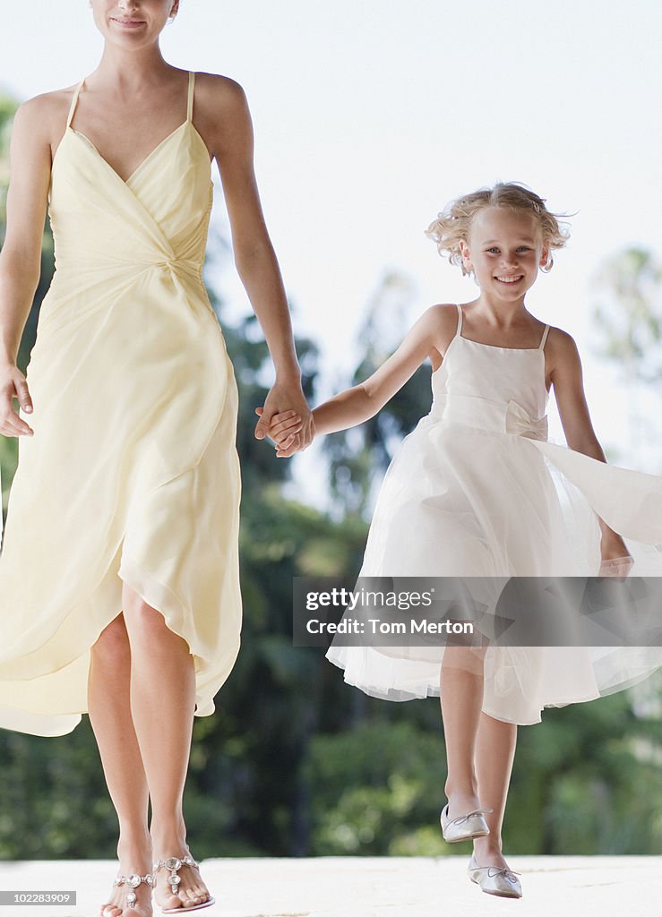 Flower girl holding hands with mother