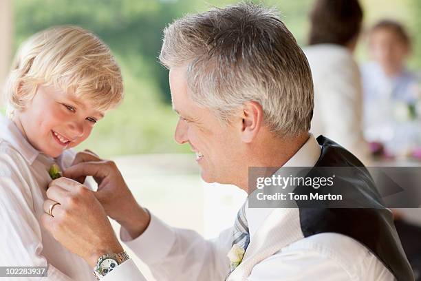 father adjusting sons tie at party - father son wedding stock pictures, royalty-free photos & images