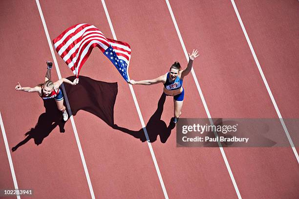 runners celebrating on track with american flag - national flag day stock pictures, royalty-free photos & images