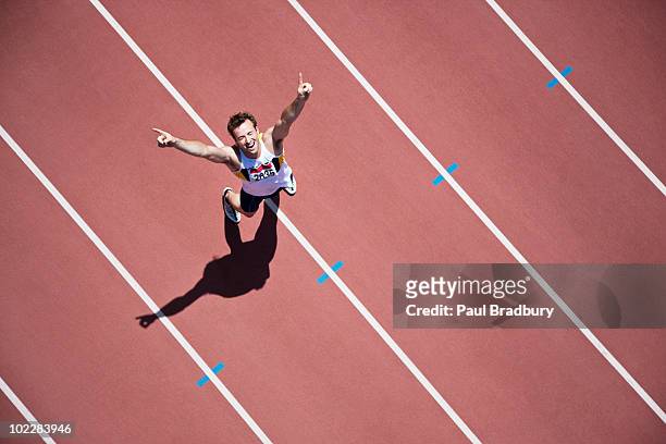 runner cheering on track - win stockfoto's en -beelden