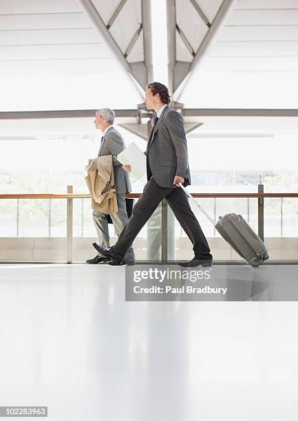 uomo d'affari tirando valigia in stazione ferroviaria - sydney airport foto e immagini stock