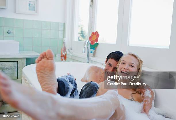 dressed couple in bubble bath - koppel toilet stockfoto's en -beelden