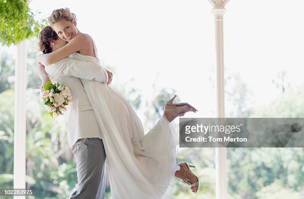 sposa e lo sposo che abbraccia sollevamento - sposa foto e immagini stock