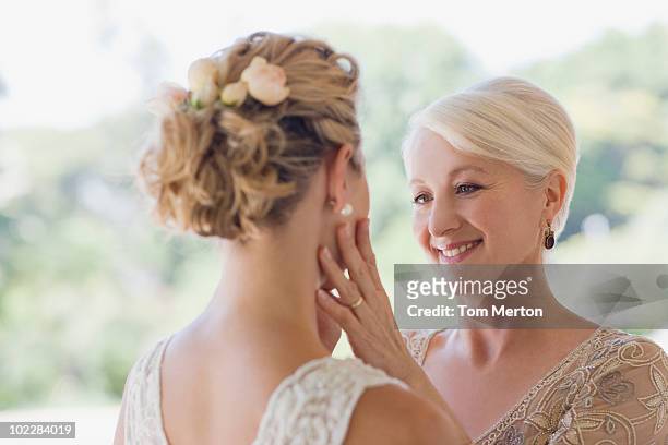 mother touching brides face - mother congratulating stock pictures, royalty-free photos & images