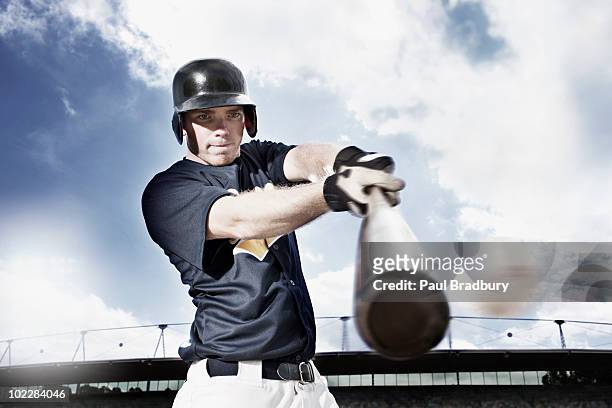 baseball player swinging baseball bat - baseball batter stock pictures, royalty-free photos & images