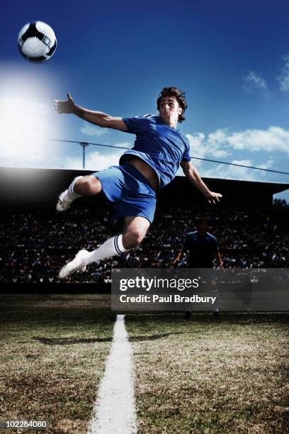 soccer player kicking soccer ball - schop stockfoto's en -beelden