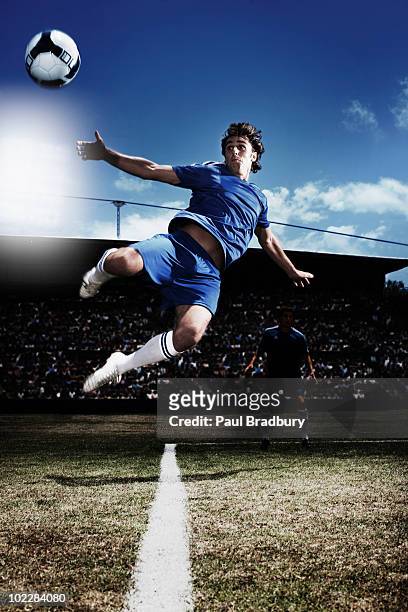 soccer player kicking soccer ball - football player stock pictures, royalty-free photos & images