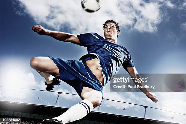 soccer player kicking soccer ball - blue sports ball stock pictures, royalty-free photos & images