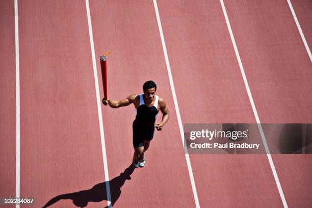 coureur jogging sur la piste avec torche - flambeau photos et images de collection