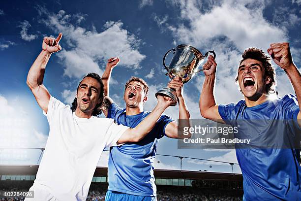soccer players cheering with trophy - the championship voetbalcompetitie stockfoto's en -beelden
