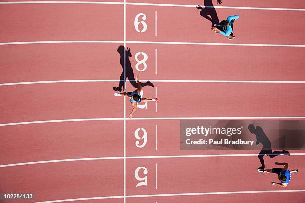 runner crossing finishing line on track - man sprinting stock pictures, royalty-free photos & images