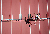 Runner jumping hurdles on track