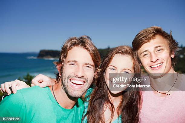 friends hugging near ocean - female with group of males stock pictures, royalty-free photos & images