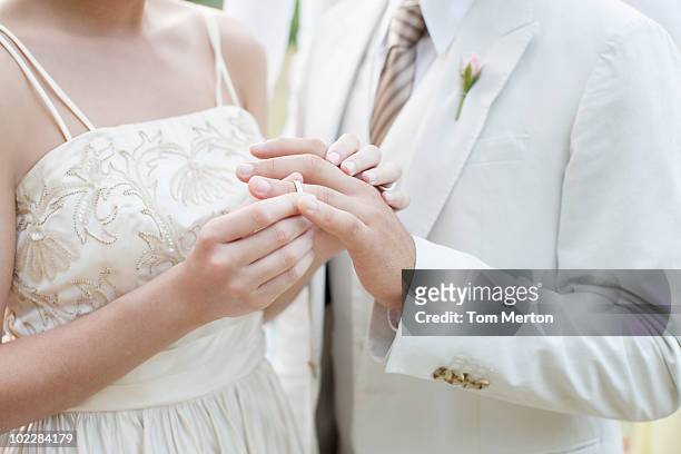 braut bräutigam putting ring am finger - wedding ceremony stock-fotos und bilder