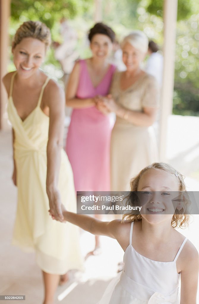 Smiling girl pulling woman by the hand