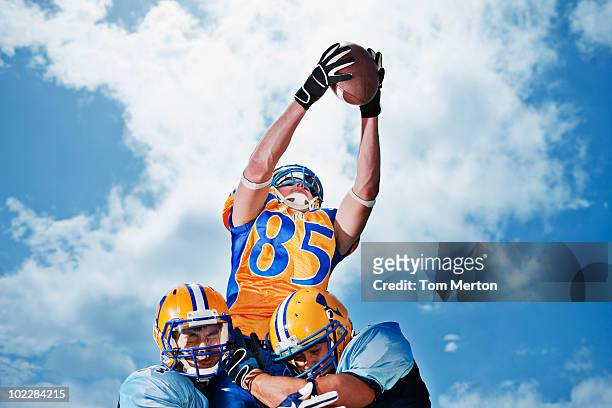 football player catching football - tackling stock pictures, royalty-free photos & images
