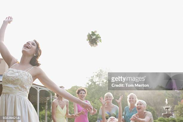 bride throwing bouquet at wedding reception - throwing stock pictures, royalty-free photos & images