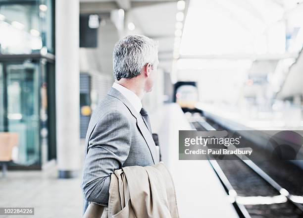 businessman waiting for train on platform - waiting stock pictures, royalty-free photos & images