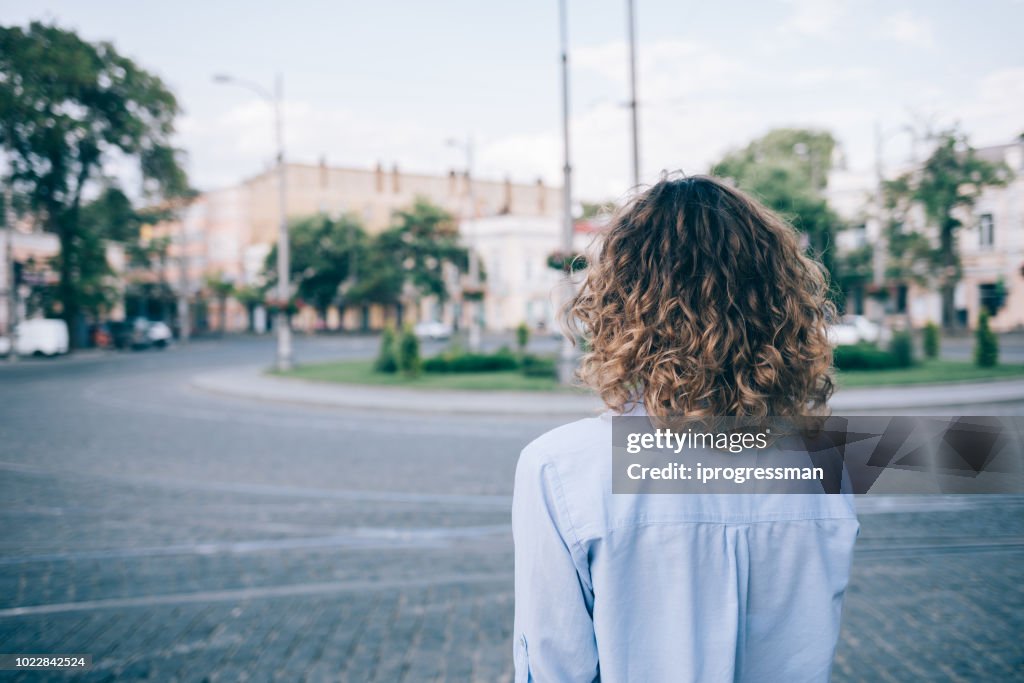 Young woman with thick curly hair looking