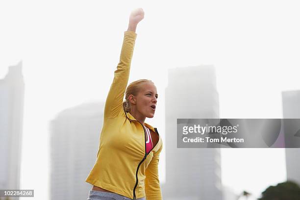 woman in city with arms raised - cheering stock pictures, royalty-free photos & images