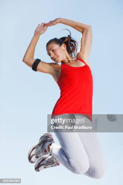 woman exercising and jumping in mid-air - jumping australia stock pictures, royalty-free photos & images