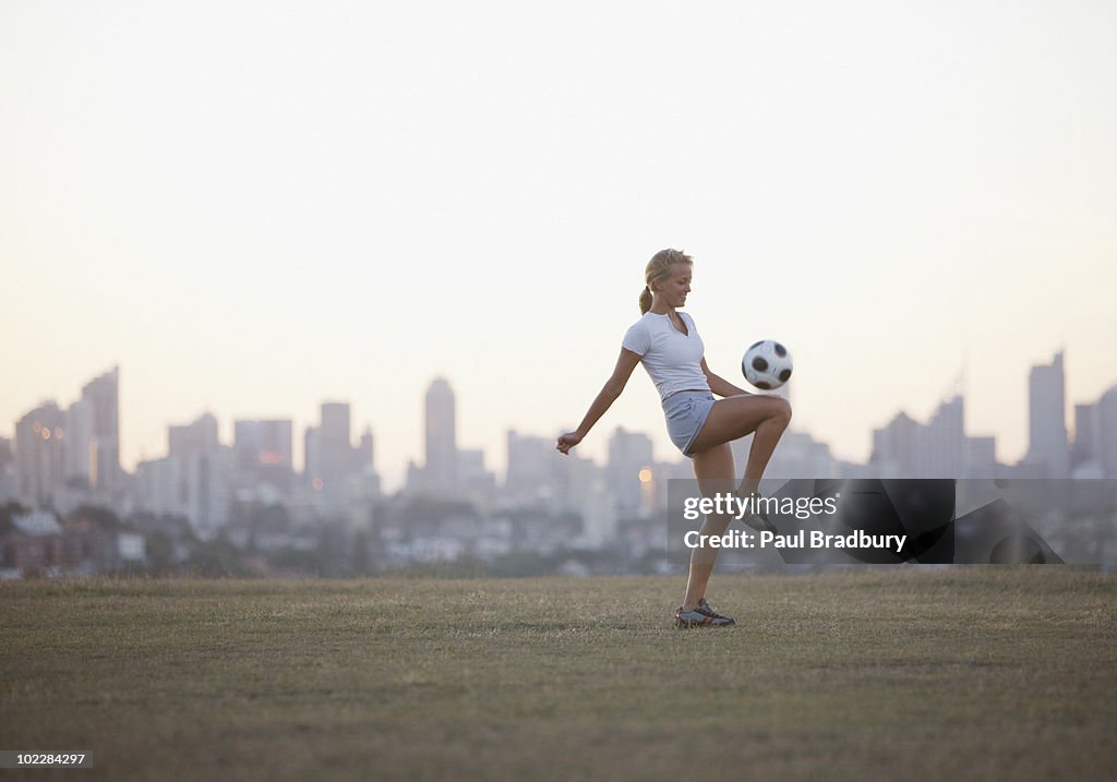 Frau kneeing Fußball ball in städtischen park