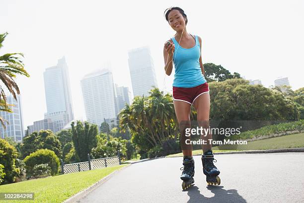 woman rollerblading in urban park - roller skating in park stock pictures, royalty-free photos & images