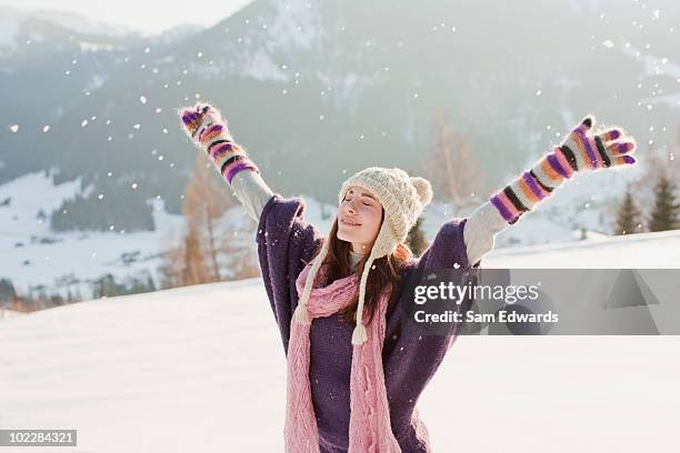 mujer con los brazos estirados en la nieve - invierno fotografías e imágenes de stock