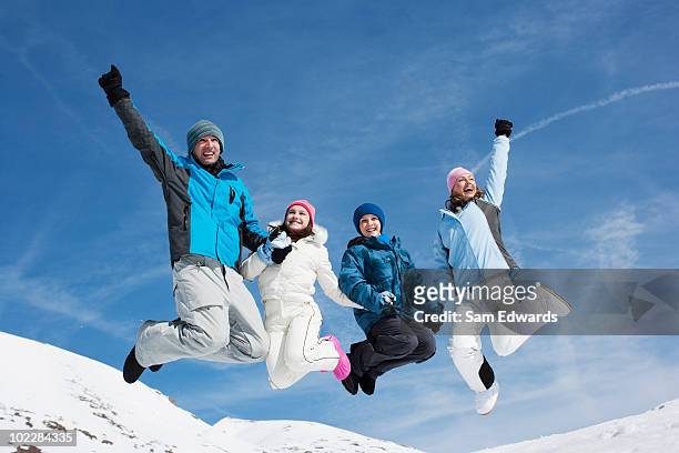 familie springen in der luft im schnee - family in snow mountain stock-fotos und bilder