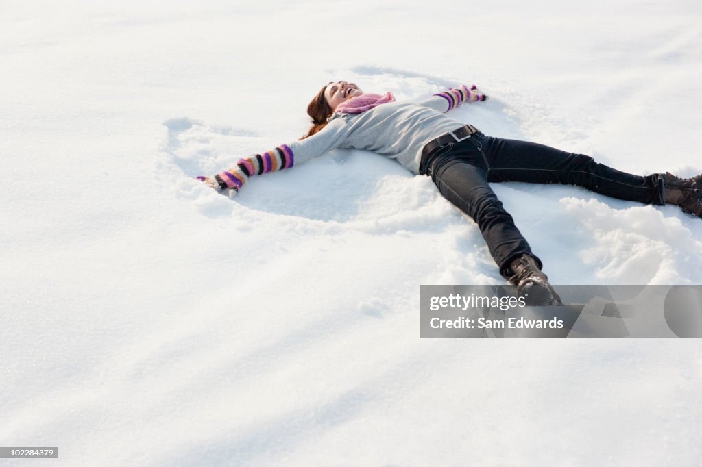 Woman making snow angel