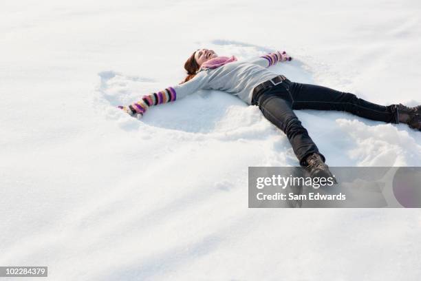 woman making snow angel - snow angel 個照片及圖片檔