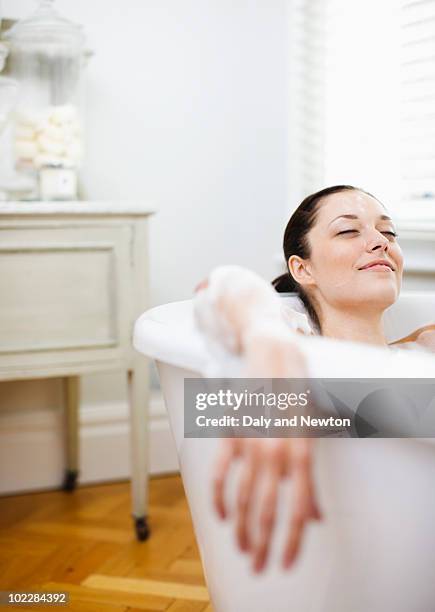 woman enjoying bubble bath - beautiful woman bath photos et images de collection