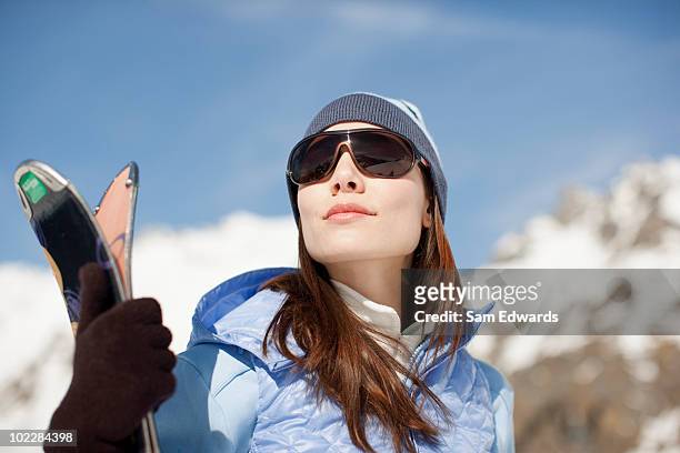 woman standing with skis - female skier stockfoto's en -beelden