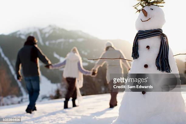 famiglia facendo pupazzo di neve - pupazzo di neve foto e immagini stock