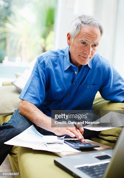 businessman using laptop on sofa - three quarter length stock pictures, royalty-free photos & images
