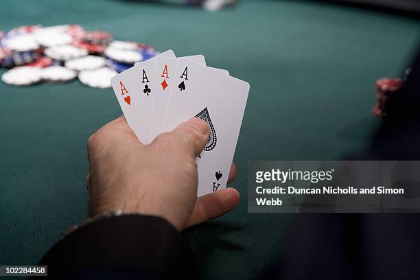 man with four aces in casino - 4 people playing games stock-fotos und bilder