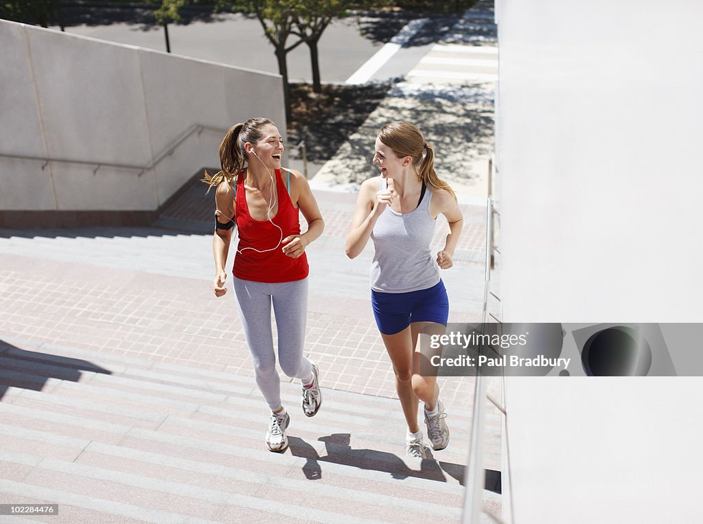 Friends running up urban staircase